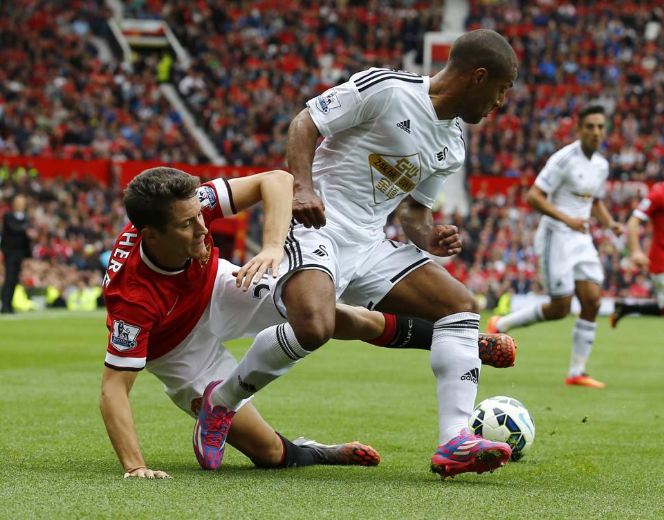 Swansea City's Routledge challenges Manchester United's Herrera during their English Premier League soccer match at Old Trafford in Manchester