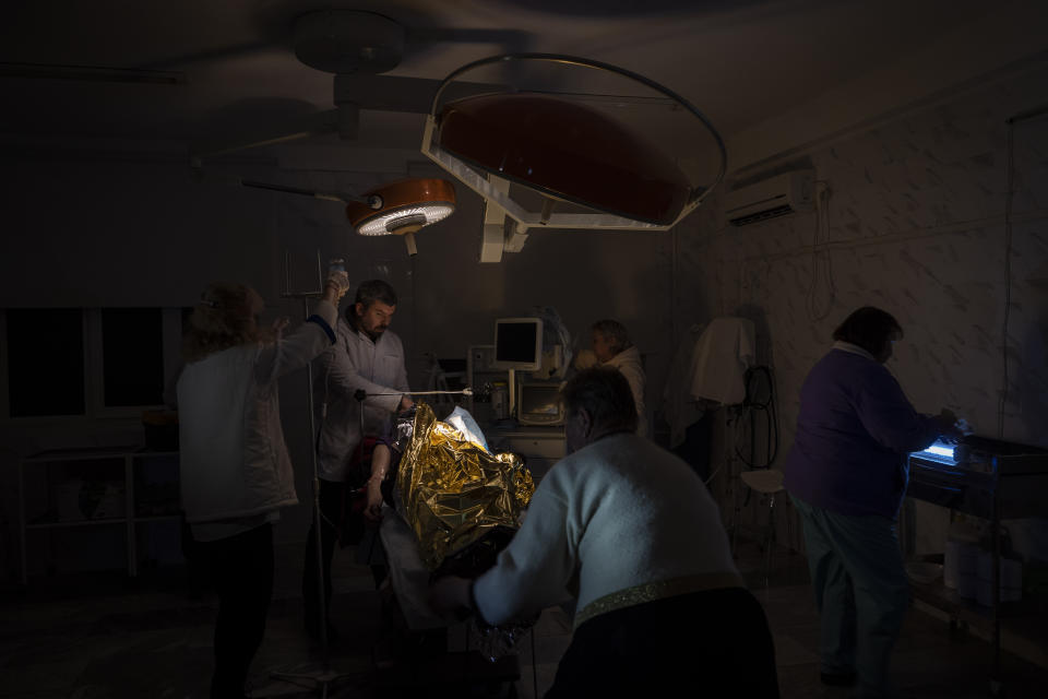 Doctors operate on 13-year-old Artur Voblikov inside a hospital in Kherson, southern Ukraine, Tuesday, Nov. 22, 2022. Arthur Voblikova was injured after a Russian strike, and doctors had to amputate his left arm. As attacks increase in the recently liberated city of Kherson, doctors are struggling to cope amid little water, electricity and a lack of equipment. (AP Photo/Bernat Armangue)