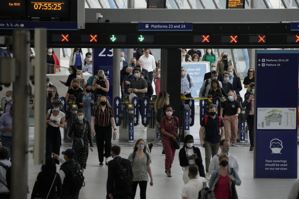 People wears face masks to curb the spread of coronavirus after disembarking from trains during the morning rush hour at Waterloo train station in London, Wednesday, July 14, 2021. London Mayor Sadiq Khan has asked Transport for London to enforce the use of mask wearing on buses and trains as a "condition of carriage", even after legal restrictions in England are lifted on July 19. Khan said he was "not prepared" to put tube, tram and other transport users in the capital "at risk" by removing the rules on face coverings. (AP Photo/Matt Dunham)