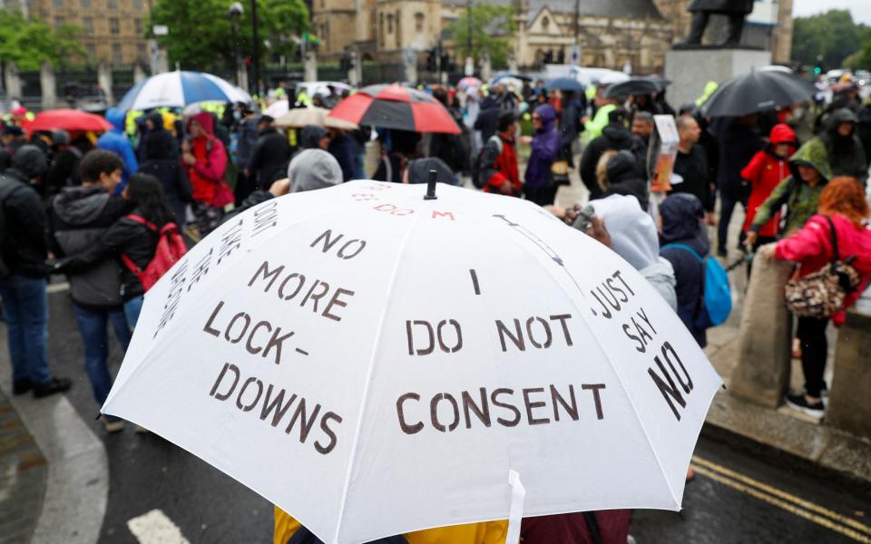 Slogans are seen on an umbrella during an anti-lockdown protest in Westminster on 21 June 2021 - Peter Nicholls/Reuters