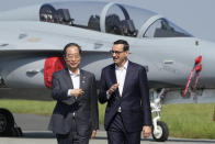South Korean Prime Minister Han Duck-Soo,left, and his Polish host, Prime Minister Mateusz Morawiecki, right, talk prior to a press conference following talks on regional security and and the examination of the FA-50 fighter jets that Poland recently bought from South Korea, along with other military equipment, at an air base in Minsk Mazowiecki, eastern Poland, Wednesday, Sept. 13, 2023. Han was in Poland for talks on regional security amid war in neighboring Ukraine, and also to discuss military and nuclear energy cooperation. (AP Photo/Czarek Sokolowski)