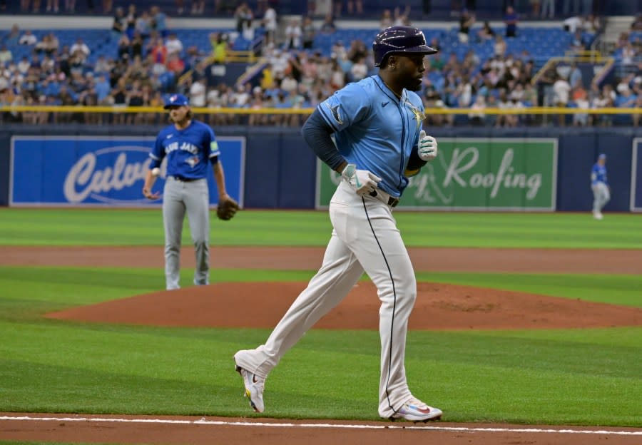 Toronto Blue Jays starter Kevin Gausman, left, watches as Tampa Bay Rays’ Randy Arozarena jogs home after hitting a solo home run during the first inning of a baseball game, Sunday, March 31, 2024, in St. Petersburg, Fla. (AP Photo/Steve Nesius)