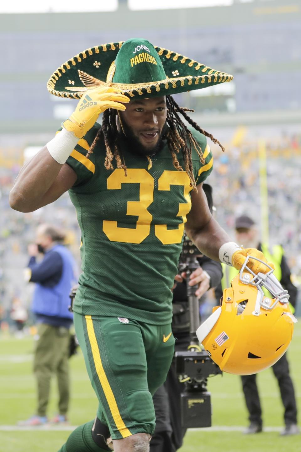 Green Bay Packers' Aaron Jones wears a hat as he runs off tghe field after an NFL football game against the Washington Football Team Sunday, Oct. 24, 2021, in Green Bay, Wis. The Packers won 24-10. (AP Photo/Aaron Gash)