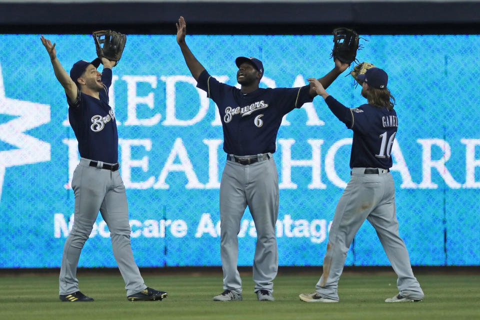 Milwaukee Brewers' Ryan Braun, left, Lorenzo Cain (6) and Ben Gamel (16) celebrate after they defeated the Miami Marlin during a baseball game, Thursday, Sept. 12, 2019, in Miami. (AP Photo/Wilfredo Lee)