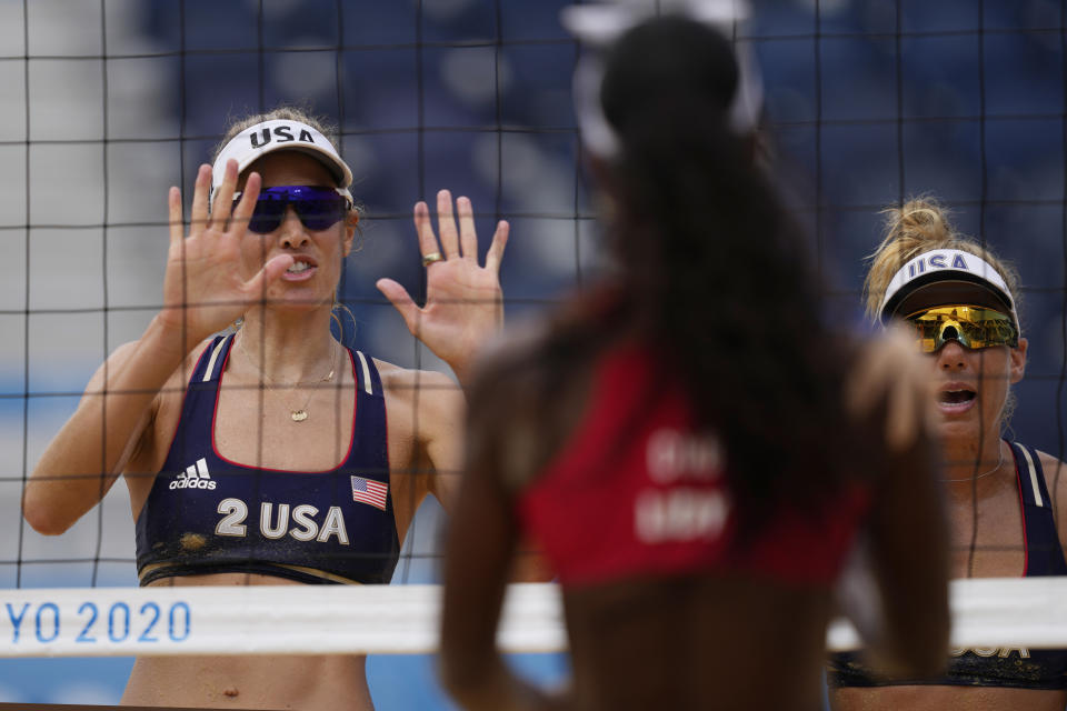 April Ross, right of the United States, and teammate Alix Klineman, left, wave to Lidianny Echevarria Benitez, center, of Cuba, After they won a women's beach volleyball match at the 2020 Summer Olympics, Monday, Aug. 2, 2021, in Tokyo, Japan. (AP Photo/Petros Giannakouris)