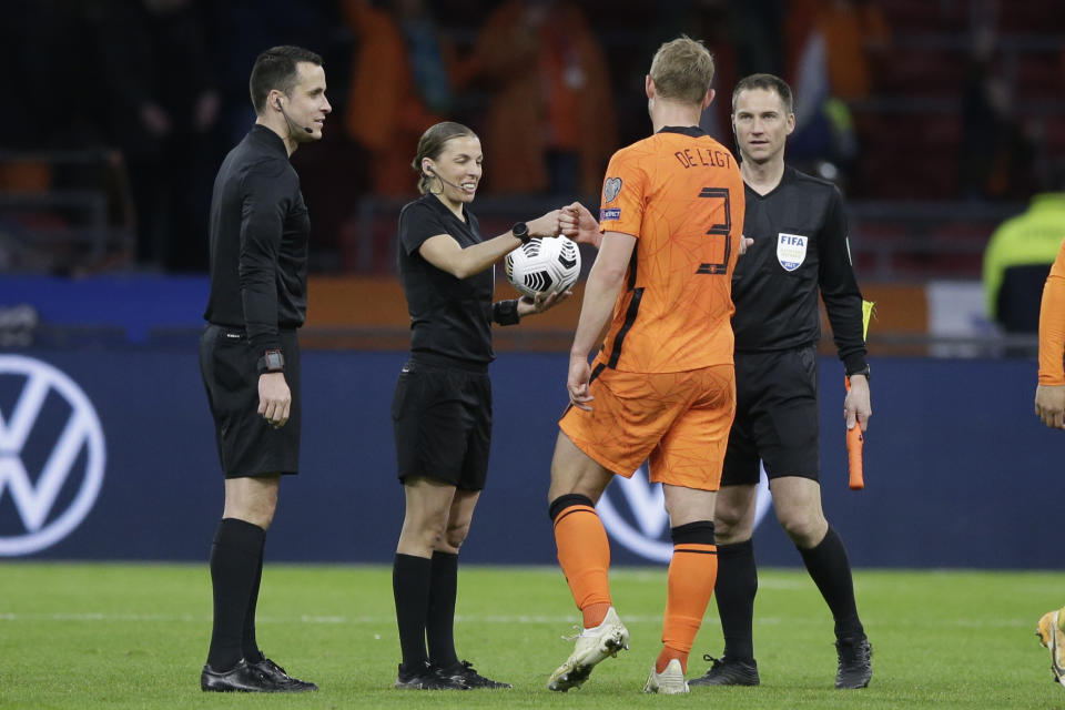 Referee Stephanie Frappart cheers with Netherlands' Matthijs de Ligt at the end of the World Cup 2022 group G qualifying soccer match between The Netherlands and Latvia at the Johan Cruyff ArenA in Amsterdam, Netherlands, Saturday, March 27, 2021. (AP Photo/Peter Dejong)