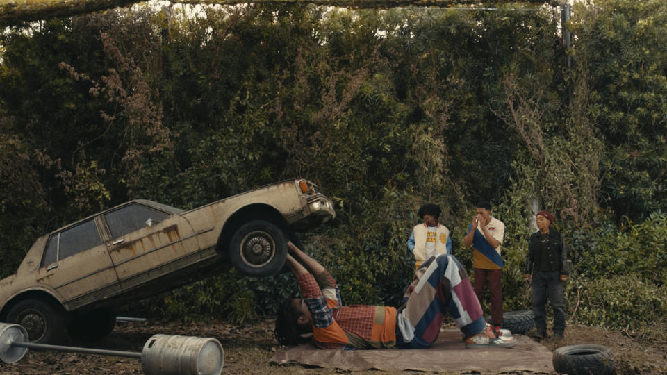 (L to R) Jharrel Jerome (Cootie) lifting a car while Allius Barnes (Scat), Brett Grey (Felix), Kara Young (Jones) watch in I'm A Virgo