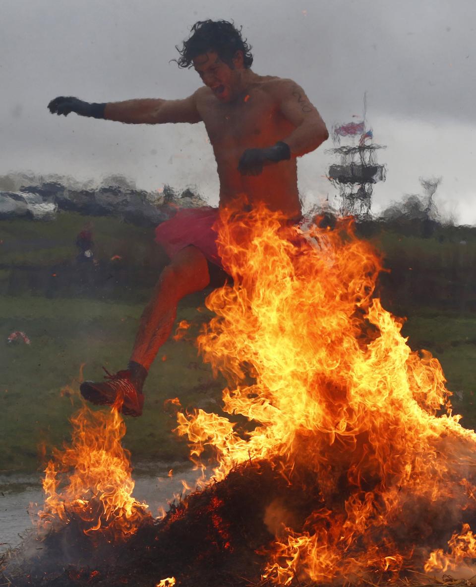 A competitor jumps across a burning obstacle during the Tough Guy event in Perton