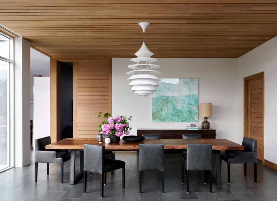 In the open dining space, a vintage light fixture sourced from eBay hangs over an Uhuru dining table and chairs from Room NYC. The sideboard is from Espasso.
