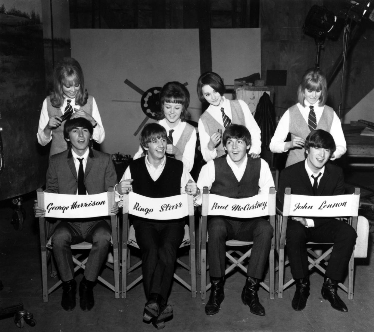 The Beatles, George Harrison, Ringo Starr, Paul McCartney and John Lennon, have their hair combed by stylists on the set of their first movie production, 
