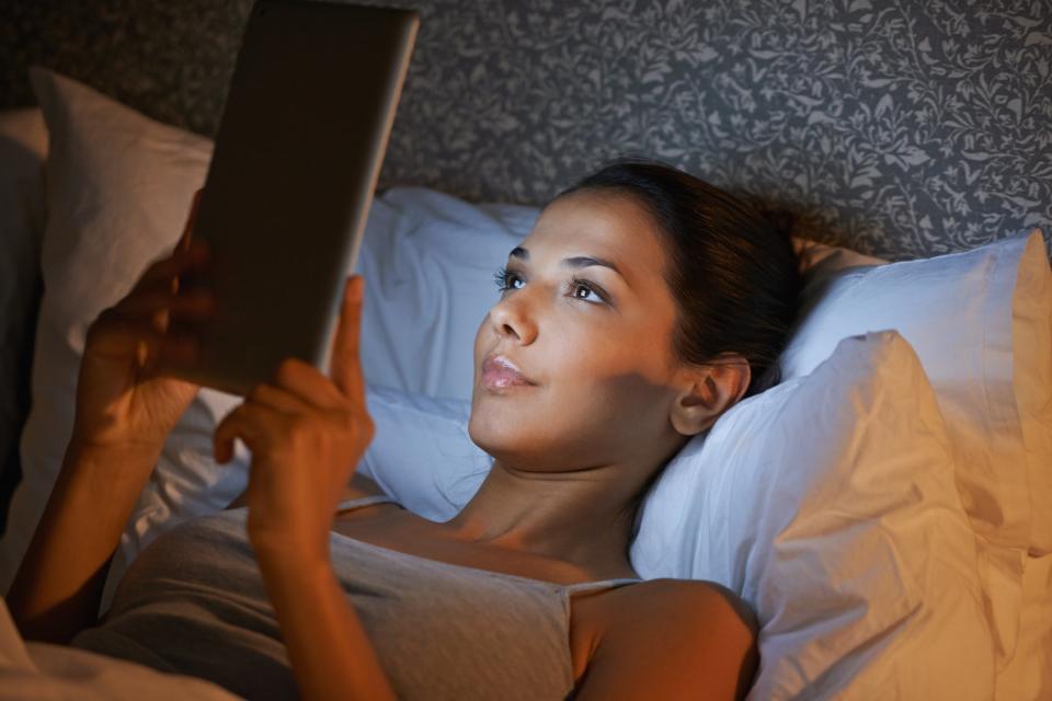 Woman with tablet in bed