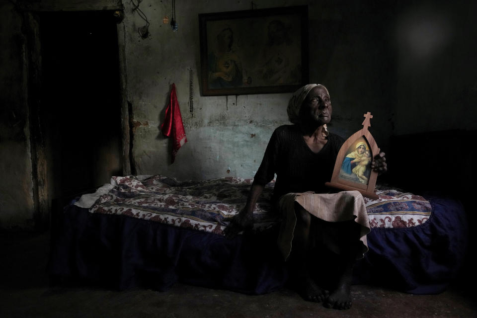 Doña Vicentina, de 96 años, permanece sentada en su cama sosteniendo una imagen de la Virgen María en el Quilombo Mesquita, una comunidad de descendientes de esclavos, durante su tradicional festival cultural y religioso "Folia do Divino Espirito Santo", el 12 de mayo de 2022, en Cidade Ocidental, Brasil, a 50 kilómetros (31 millas) de la capital brasileña, Brasilia. El festival se lleva a cabo desde hace más de 100 años la víspera del 13 de mayo, fecha en la que Brasil abolió la esclavitud en 1888. (AP Foto/Eraldo Peres)