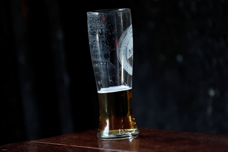 FILE PHOTO: An unfinished pint of beer stands outside a pub in central London