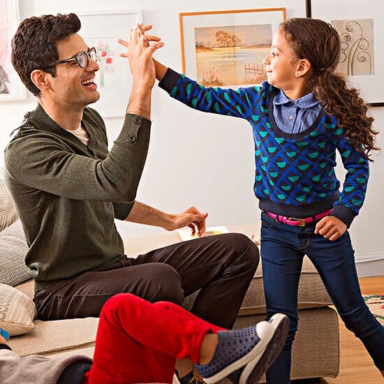 Girl and dad high-fiving