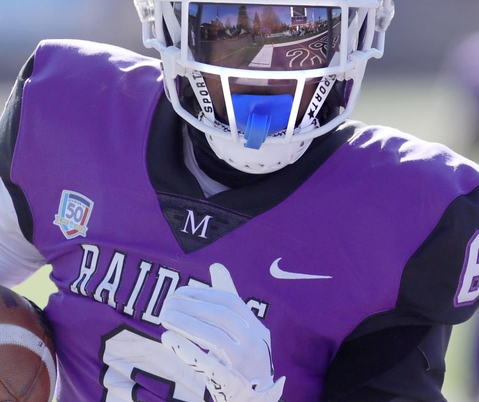 A wide open end zone is reflected in Wayne Ruby Jr.'s visor as he scores a first-half touchdown in a first-round NCAA Division III playoff game against Alfred State in 2023.