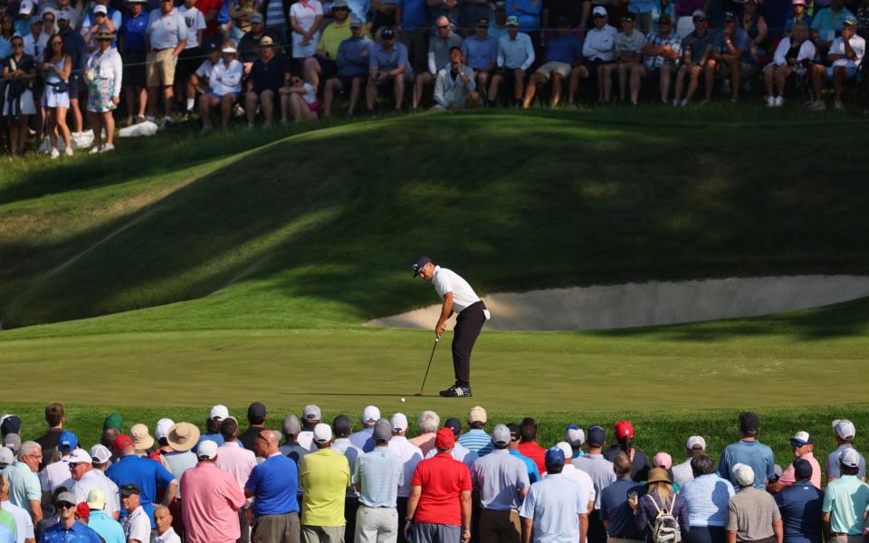 Xander Schauffele of the United States putts on the 14th green