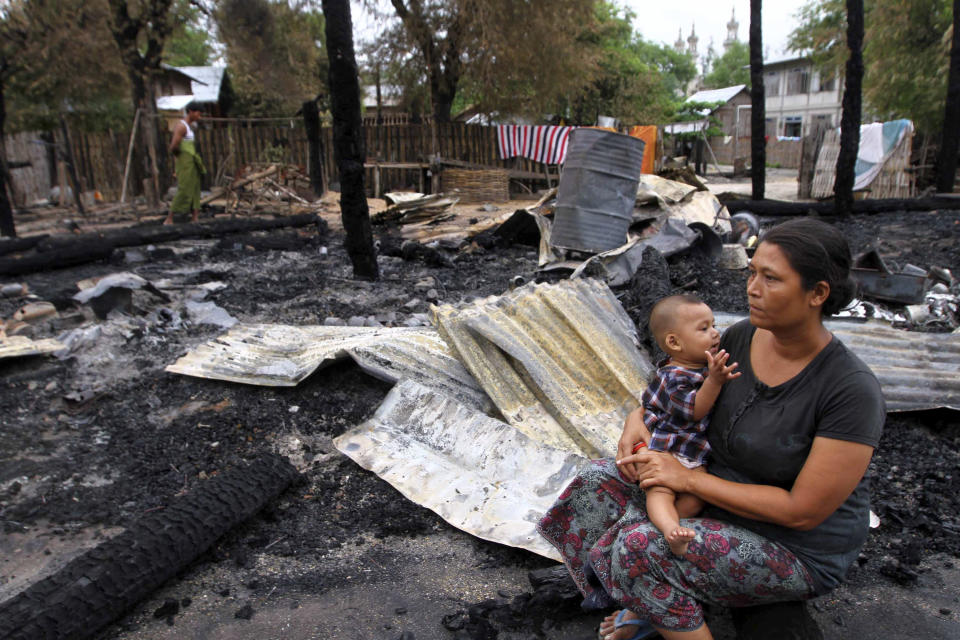 A woman and a child sit near their burnt house after violence in Htan Gone village of Kantbalu township, Sagaing division, Myanmar, Monday, Aug. 26, 2013. A tense calm returned Monday to a Myanmar town that was ripped apart by sectarian violence, leaving hundreds homeless after Buddhist mobs tore through the small, winding streets torching Muslim-owned houses and stores. (AP Photo/Khin Maung Win)