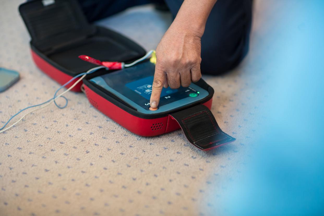 CPR training using and an AED and bag mask valve on an adult training manikin.  First aid cardiopulmonary resuscitation course using automated external defibrillator device, AED.