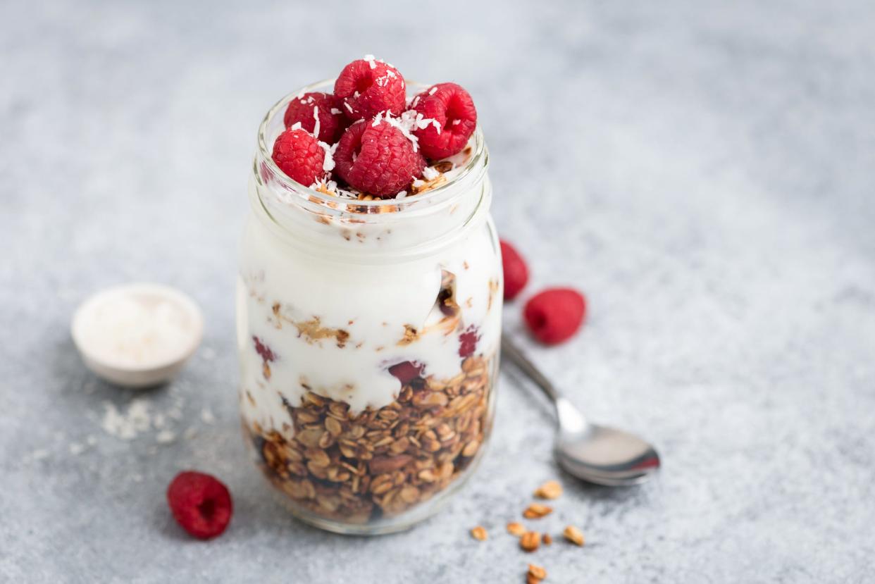 A yogurt parfait in a jar with berries and granola.