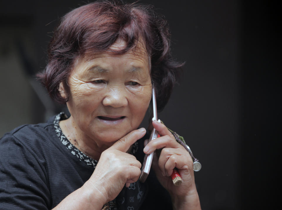 In this Saturday, Sept. 29, 2012 photo, an elderly woman speaks on her mobile phone at a shrine in Tokyo. The U.N. Population Fund has urged governments to build safety nets to ensure that older people have income security and access to essential health and social services as the world's elderly population grows. The U.N. agency said discrimination toward and poverty among the aged are still far too prevalent in many countries. It released its report Monday, Oct. 1, 2012 in Tokyo, capital of the world's fastest-aging country. (AP Photo/Itsuo Inouye)