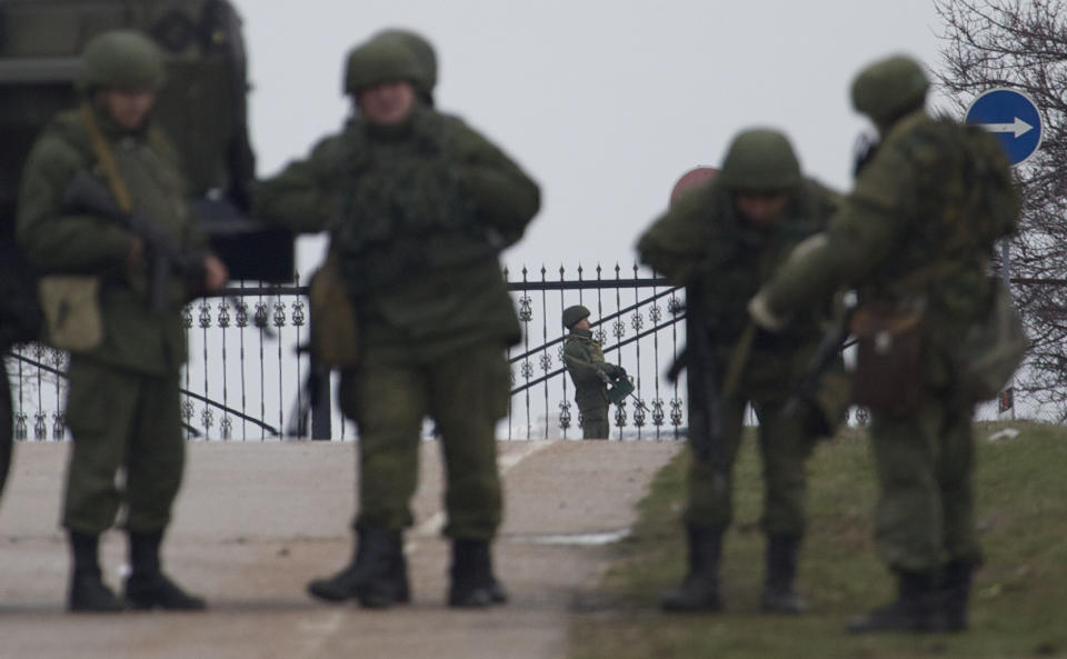 Unidentified gunmen wearing camouflage uniforms guard the entrance to the military airport at the Black Sea port of Sevastopol in Crimea, Ukraine, Friday, Feb. 28, 2014. Russian troops took control of the two main airports in the strategic peninsula of Crimea, Ukraine's interior minister charged Friday, as the country asked the U.N. Security Council to intervene in the escalating conflict. Russian state media said Russian forces in Crimea denied involvement. No violence was reported at the civilian airport in Crimea's capital of Simferopol or at the military airport in the Black Sea port of Sevastopol, also part of Crimea. At the Simferopol airport, a man claiming to speak for the camouflage-clad forces patrolling the airport described them as Crimean militiamen. (AP Photo/Ivan Sekretarev)