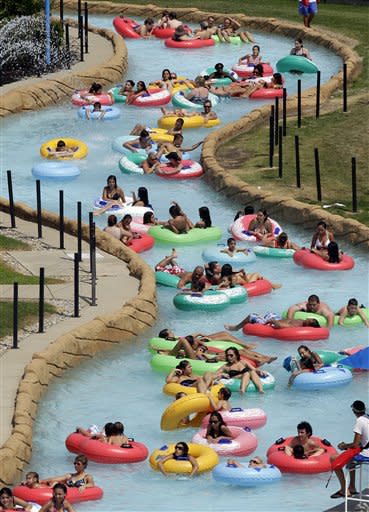 Swimmers try and keep cool in near 100 degree temperatures on a lazy river at Red Oaks Waterpark in Madison Heights, Mich., Thursday, June 28, 2012. (AP Photo/Paul Sancya)
