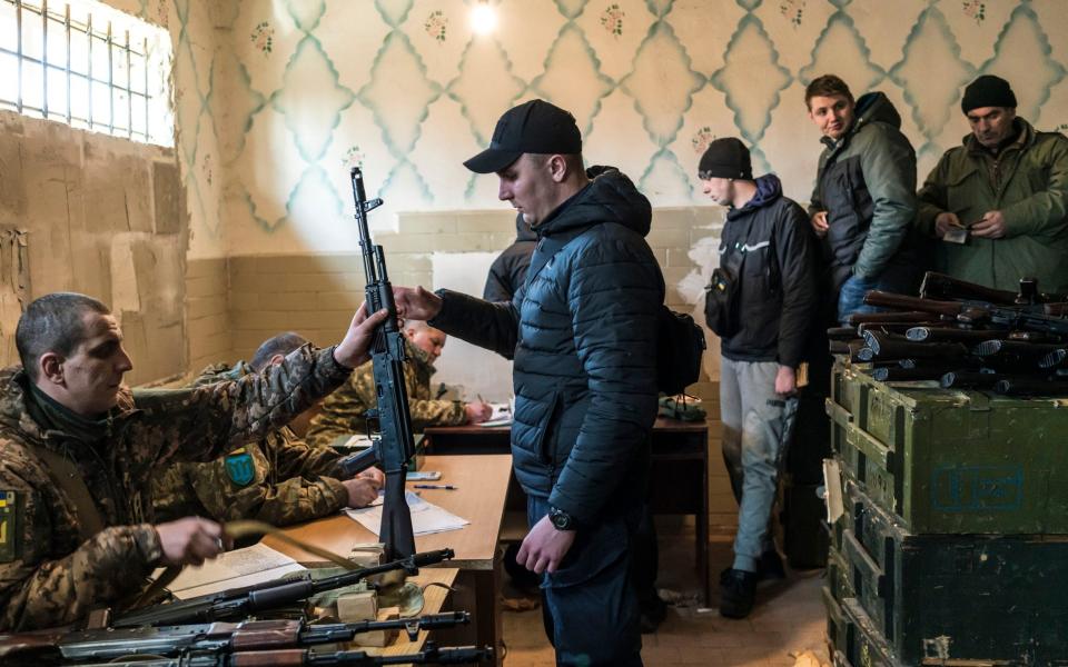 Ukrainian military volunteers recieve weapons at a weapons storage facility in Fastiv, Ukraine, - NYT