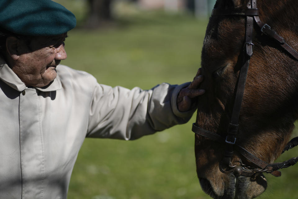 Oscar Villafane pets Coco the horse at the San Jose Home for seniors where he lives in Tandil Argentina, Wednesday, Sept. 15, 2021. The residence took in the horse during the COVID-19 lockdown to cheer up their elderly residents. (AP Photo/Natacha Pisarenko)