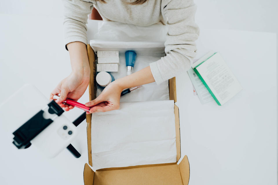 Hands taking beauty products out of a subscription box