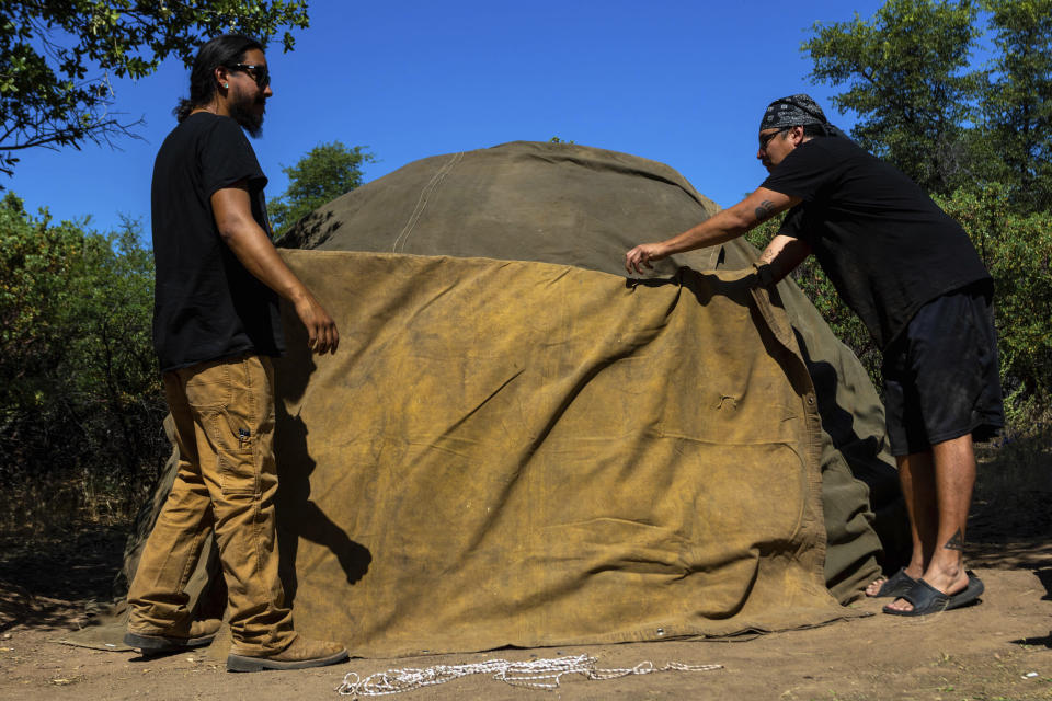 Men work to build a sweat lodge on Oak Flat Campground, a sacred site for Native Americans located 70 miles east of Phoenix, on June 3, 2023, in Miami, Ariz. Resolution Copper Mining, a joint subsidiary of British and Australian mining giants, Rio Tinto and BHP, has proposed a massive copper mine on the flats, which could threaten spiritual practices and heritage. (AP Photo/Ty O'Neil)