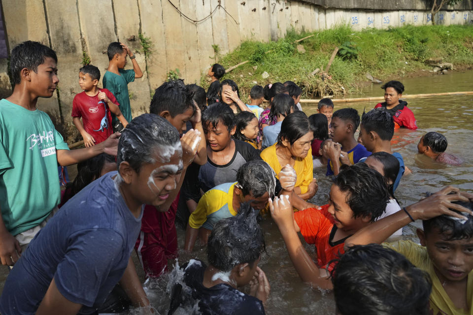 Children bathe in the Cisadane River, ahead the holy fasting month of Ramadan in Tangerang, Indonesia, Tuesday, March 21, 2023. Muslims followed local tradition to wash in the river to symbolically cleanse their soul prior to entering the holiest month in Islamic calendar. (AP Photo/Tatan Syuflana)