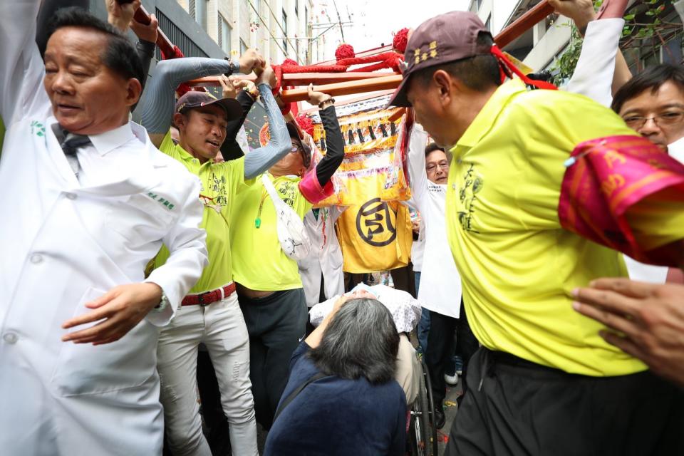 ▲大甲媽鑾轎回鑾停駕員林市宏仁醫院，多位白袍醫師扛轎祈福，院方也設置點心站，並設置醫療站服務香客傷痛問題。（宏仁醫院提供）