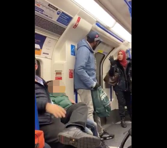 Asma Shuweikh speaks to a man on a London subway car who is accused of harassing a Jewish family. (Photo: @scatatkins)