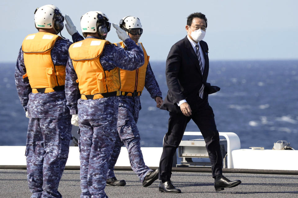 FILE - Japanese Prime Minister Fumio Kishida walks on the Maritime Self Defense Force's helicopter carrier JS Izumo during an international fleet review in Sagami Bay, southwest of Tokyo, on Nov. 6, 2022. Japan adopted a new five-year ocean policy on Friday, April 28, 2023, that calls for stronger maritime security, including bolstering its coast guard's capability and cooperation with the military amid China’s increasing assertiveness in regional seas.(Kyodo News via AP, File)