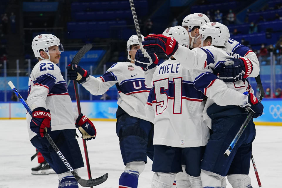United States players celebrate after a goal by Kenny Agostino during a preliminary round men's hockey game against Canada at the 2022 Winter Olympics, Saturday, Feb. 12, 2022, in Beijing. (AP Photo/Matt Slocum)