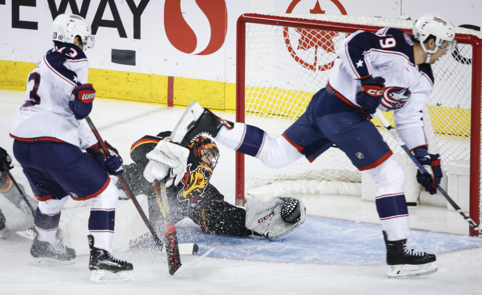 Columbus Blue Jackets forward Yegor Chinakhov (59) scores on Calgary Flames goalie Jacob Markstrom (25) during the first period of an NHL hockey game Thursday, Jan. 25, 2024, in Calgary, Alberta. (Jeff McIntosh/The Canadian Press via AP)