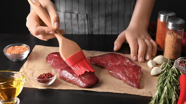 brushing steak cuts with oil