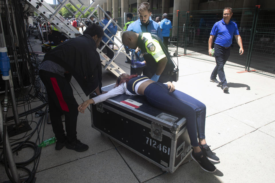 A woman is treated by a paramedic after being pulled from the crowd during the Toronto Raptors NBA basketball championship parade in Toronto, Monday, June 17, 2019. (Chris Young/The Canadian Press via AP)