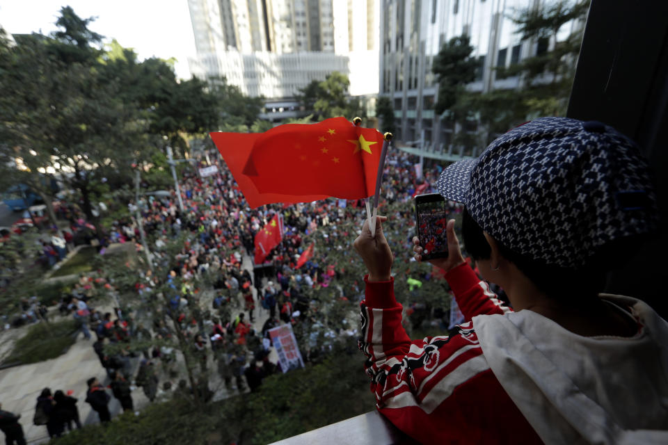 Pro-Beijing supporters wave the Chinese national flags during a rally in Hong Kong on Saturday, Dec. 7, 2019. Six months of unrest have tipped Hong Kong's already weak economy into recession. (AP Photo/Mark Schiefelbein)