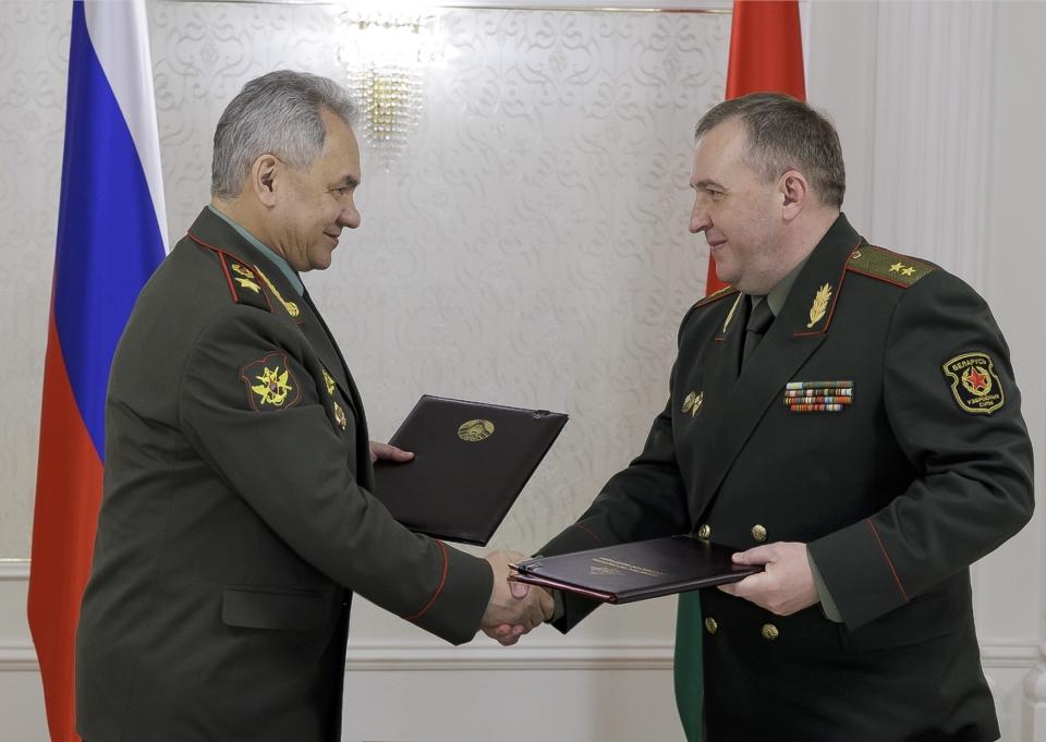 Russian Defense Minister Sergei Shoigu, left, and Belarusian Defense Minister Viktor Khrenin exchange documents during a meeting after a session of the Council of Defense Ministers of the Collective Security Treaty Organization (CSTO) in Minsk, Belarus, Thursday, May 25, 2023. (Vadim Savitsky/Russian Defense Ministry Press Service via AP)