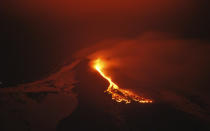 In this photo, lava flows during an eruption of the snow capped Mount Etna volcano, near the Sicilian town of Catania, southern Italy. (AP Photo/Davide Caudullo, Lapresse)