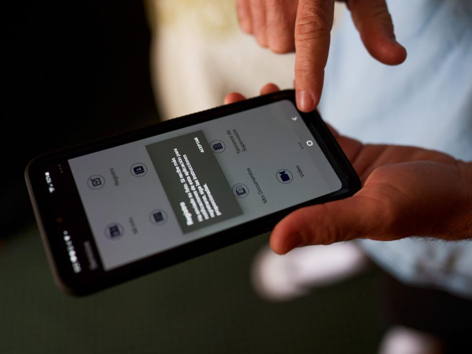 An asylum seeking migrant shows the phone he was given to take photos of himself for check-ins with Immigration and Customs Enforcement in a shelter run by Colores United, as U.S. border agents and advocates prepare for possible rollback of the coronavirus disease (COVID-19) restrictions in Deming, New Mexico, U.S., March 31, 2022.