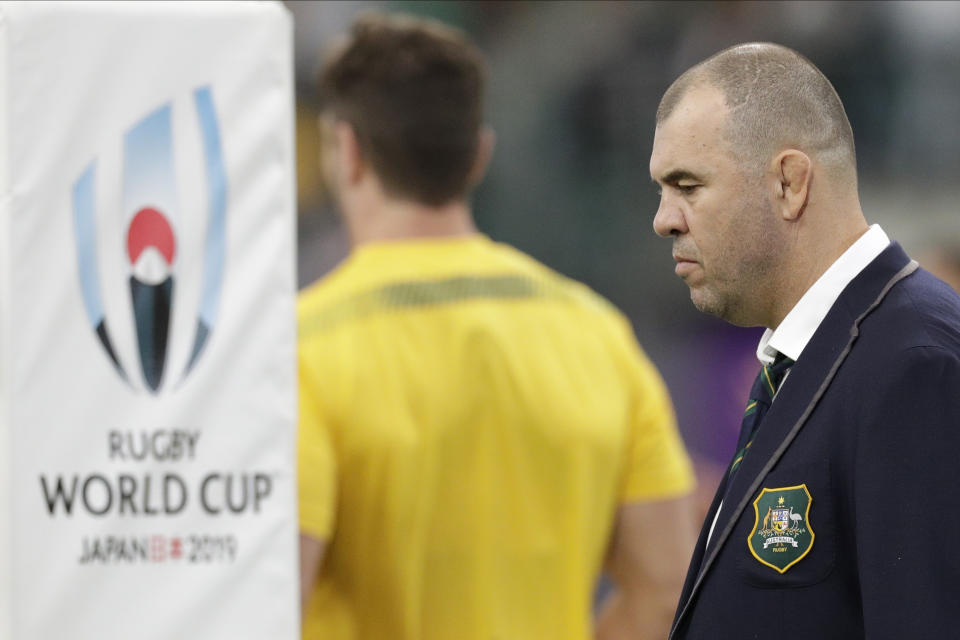 Australia coach Michael Cheika watches as his team warm up before the Rugby World Cup quarterfinal match at Oita Stadium between England and Australia in Oita, Japan, Saturday, Oct. 19, 2019. (AP Photo/Aaron Favila)