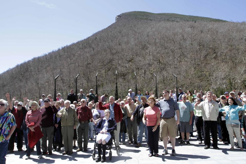 FILE - Hundreds of people gather at a park below where the Old Man of the Mountain was once seen, Friday, May 3, 2013, in Franconia, N.H. during a ceremony for the 10th anniversary of the date the natural rock formation and state emblem crashed to the ground. (AP Photo/Jim Cole, File)