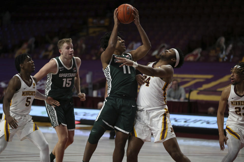 Michigan State's A.J. Hoggard (11) pushes up to the basket against Minnesota's Eric Curry (24) during the second half of an NCAA college basketball game, Monday, Dec. 28, 2020, in Minneapolis. Minnesota won 81-56. (AP Photo/Stacy Bengs)