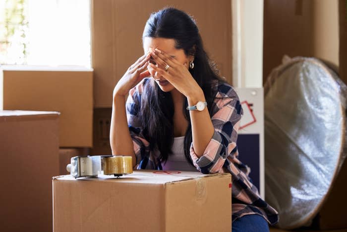 Woman stressed with moving boxes in her house