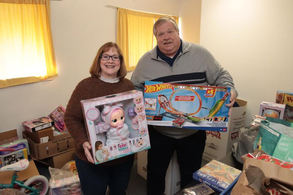 Colleen and Mike Sunderland of the Tecumseh Service Club are pictured Thursday with toys that will be distributed as part of the club's Christmas Sponsor-a-Family program.