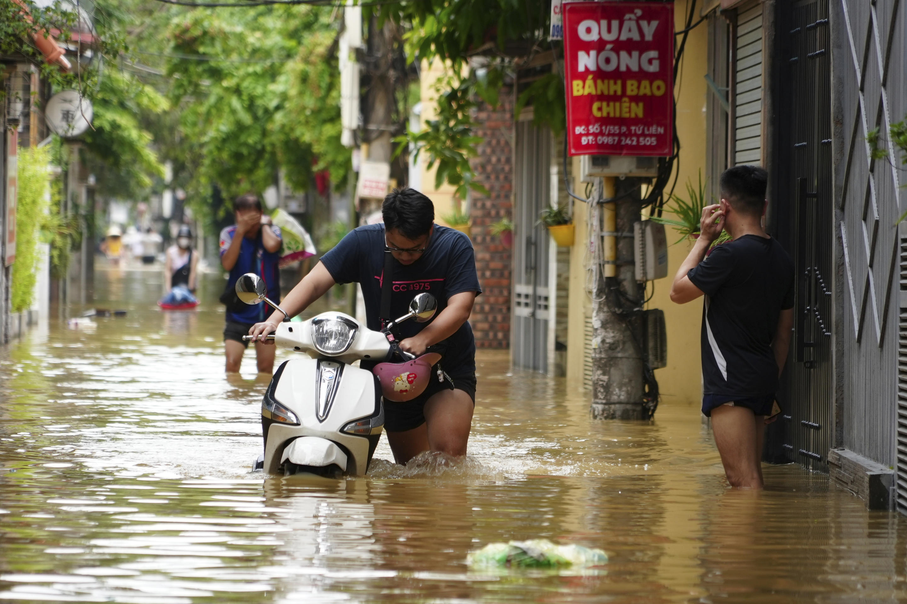 People wade in a flooded street in the aftermath of Typhoon Yagi, in Hanoi, Vietnam on Thursday, Sep. 12, 2024. (Hau Dinh/AP)