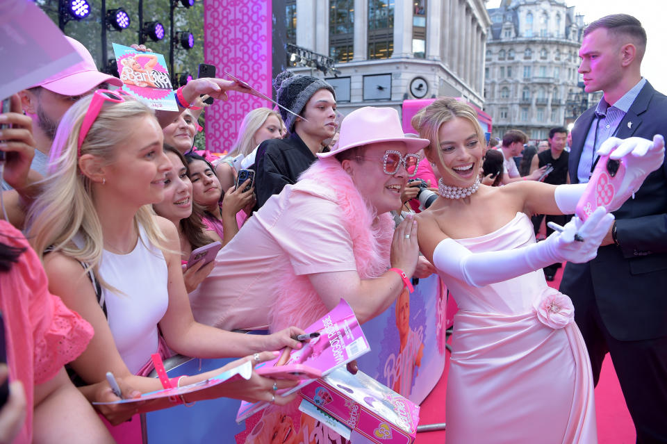 LONDON, ENGLAND - JULY 12: Margot Robbie takes a selfie with fans during The European Premiere Of "Barbie" at Cineworld Leicester Square on July 12, 2023 in London, England. (Photo by Antony Jones/Getty Images for Warner Bros.)