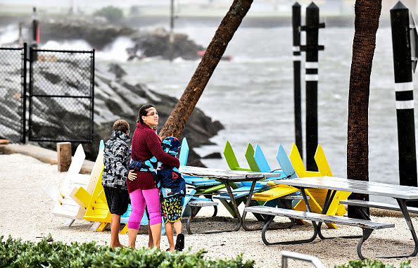 Local residents walk in the middle of rain and heavy wind at the St. Pete pier as the Hurricane Ian hits the west coast on September 28, 2022, in St. Petersburg, Florida.